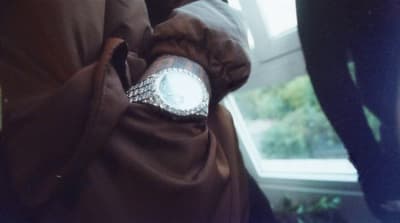 a woman wearing a ring with diamonds on it