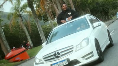 a man standing on the hood of a white car