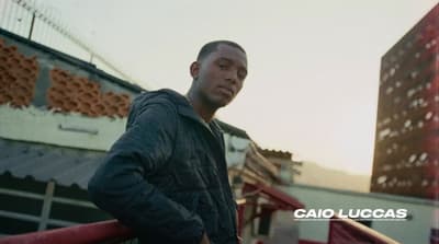 a man standing on top of a balcony next to a tall building