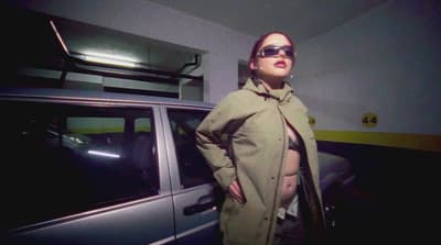 a woman standing next to a car wearing sunglasses