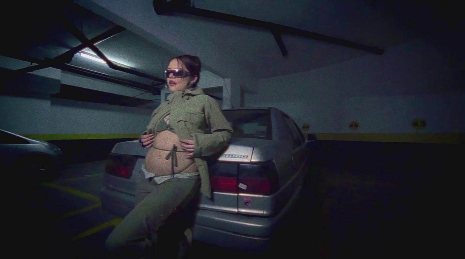 a woman standing next to a car in a garage