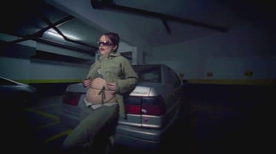 a woman standing next to a car in a garage