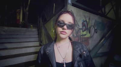 a woman wearing sunglasses and a leather jacket