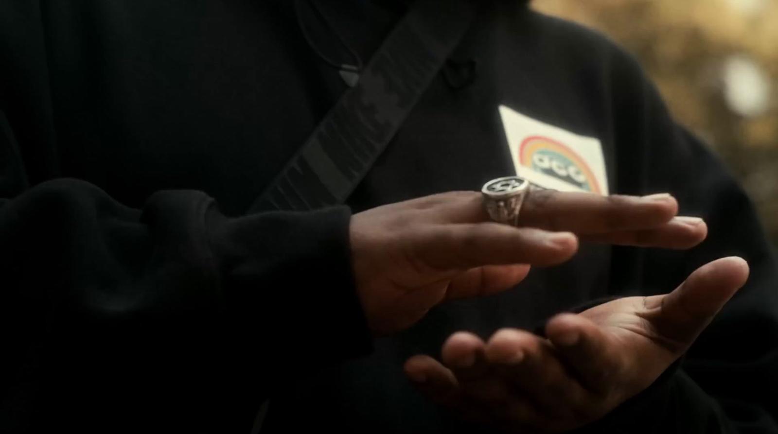 a man wearing a ring holding a playing card