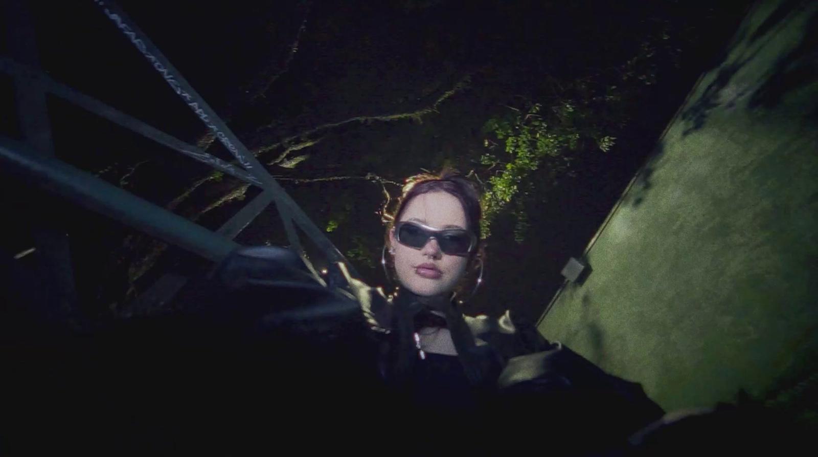 a woman wearing sunglasses standing on a stairway