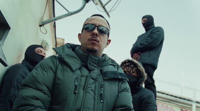a man in a green jacket wearing sunglasses