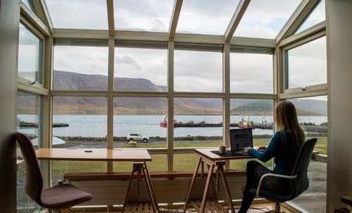 a woman sitting at a desk in front of a window