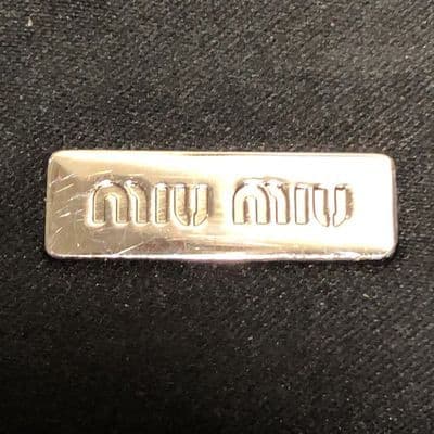 a metal name plate on a black surface