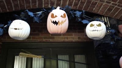 a group of pumpkins hanging from a brick wall