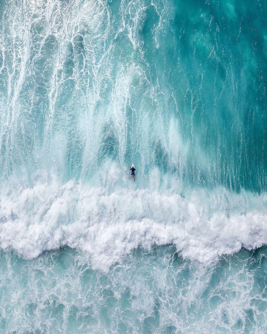 a man riding a wave on top of a surfboard