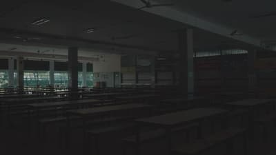 an empty classroom with desks and windows