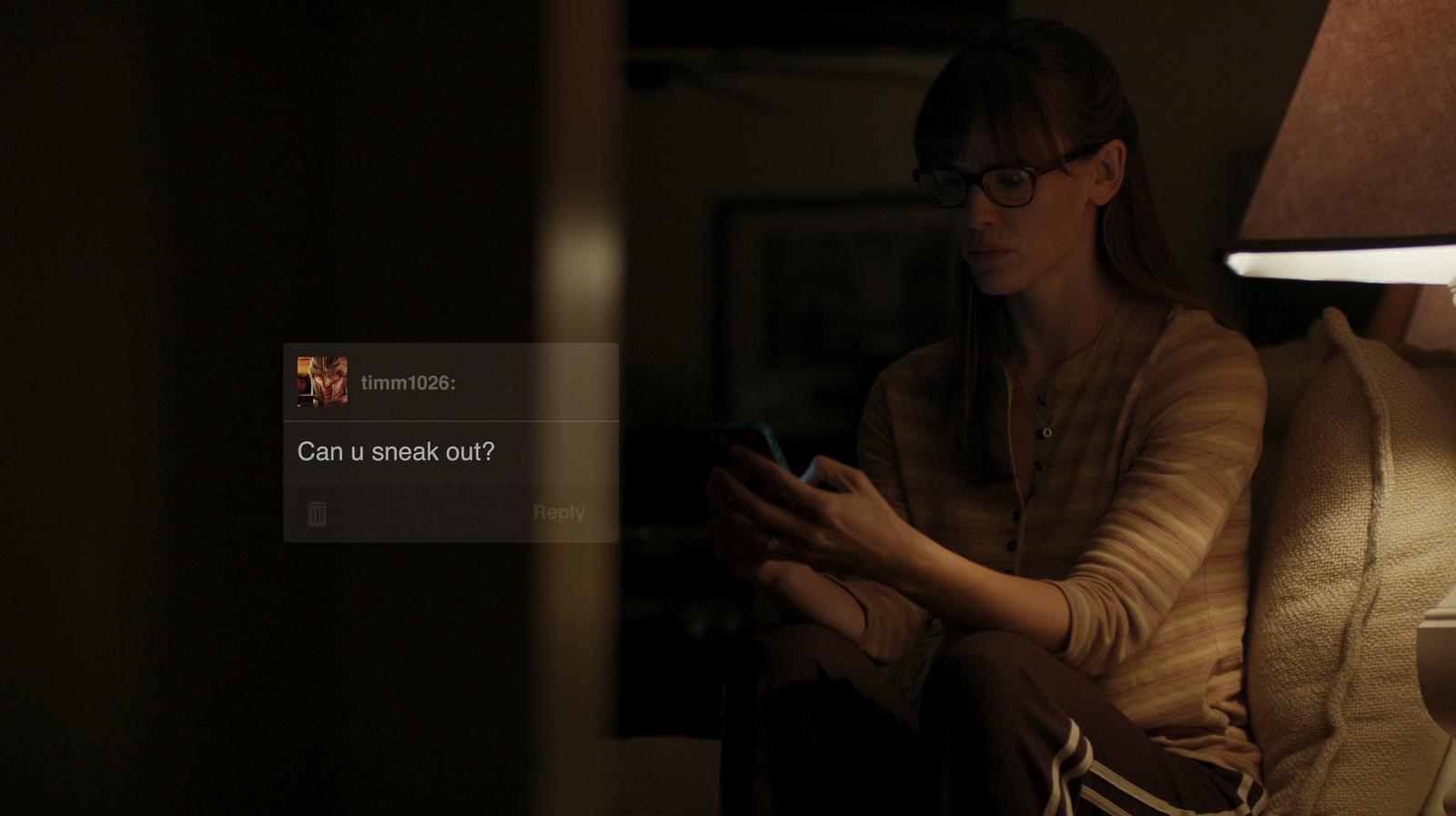 a woman sitting on a couch looking at her cell phone