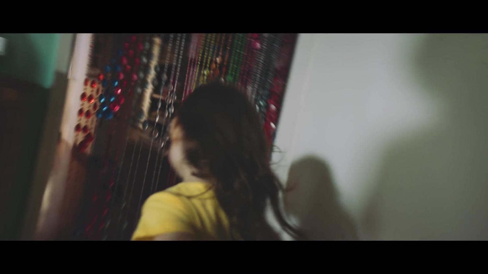 a woman standing in front of a wall with beads on it