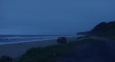 a car parked on the side of a road next to the ocean