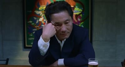 a man sitting at a table with a glass of beer