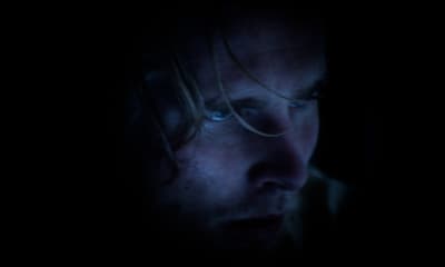 a man in a dark room staring at something