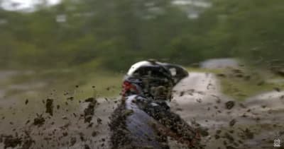 a person riding a dirt bike through a puddle of water