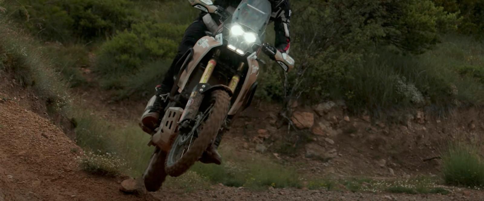 a man riding a motorcycle down a dirt road