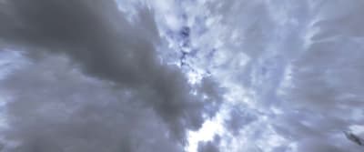 a cloudy sky with a plane flying in the distance