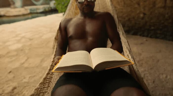 a man sitting on a bench reading a book