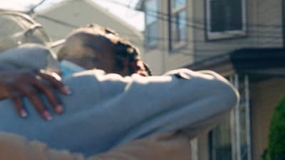 a person hugging another person in front of a house