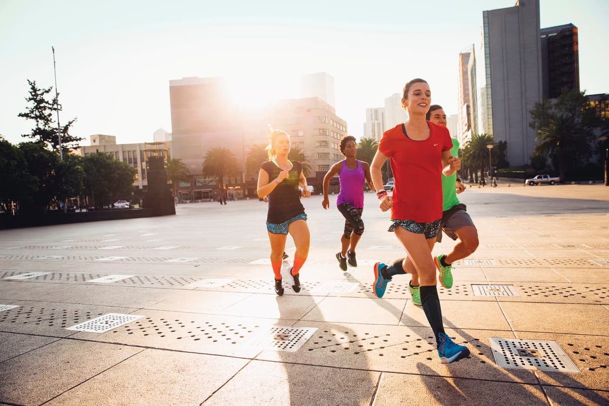 a group of women running on a city street