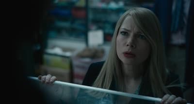 a woman with long blonde hair standing in front of a mirror