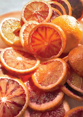 a pile of sliced oranges sitting on top of a white plate