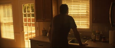 a person standing in a kitchen next to a sink