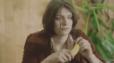 a woman holding a banana in her right hand