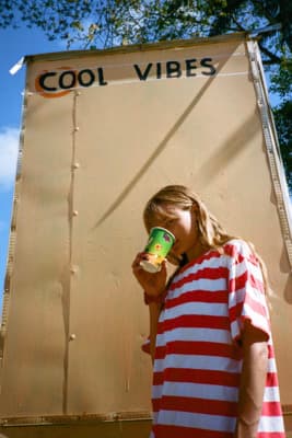 a girl in a striped shirt drinking from a cup