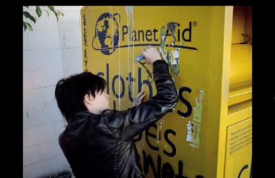 a person putting a ticket into a yellow machine