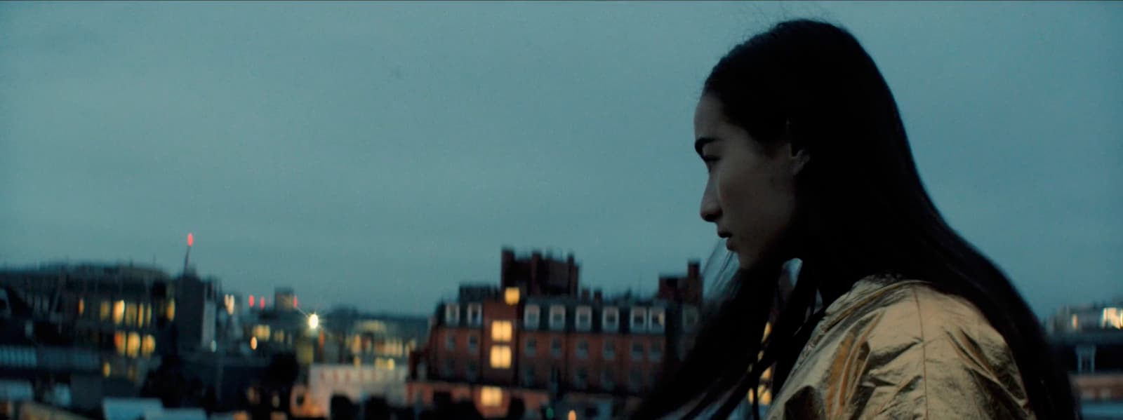 a woman with long hair standing in front of a building