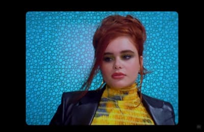 a woman with red hair wearing a black leather jacket