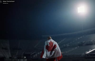 a man with a canadian flag draped over his shoulders