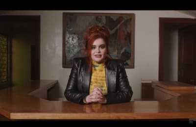 a woman with red hair wearing a yellow scarf