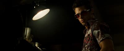 a man standing in front of a light in a dark room