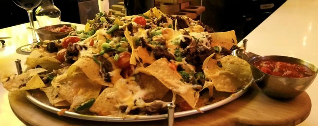 a platter of nachos and salsa on a table
