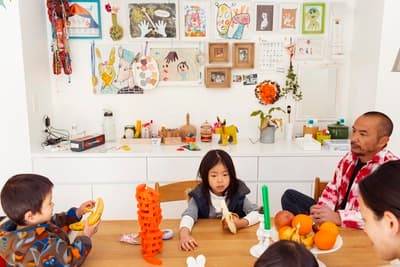a group of children sitting around a table eating fruit