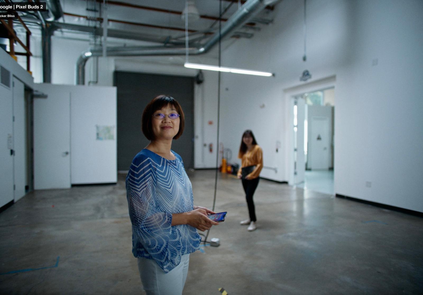 a woman standing in a room holding a remote