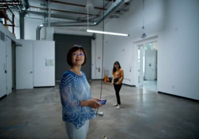 a woman standing in a room holding a remote