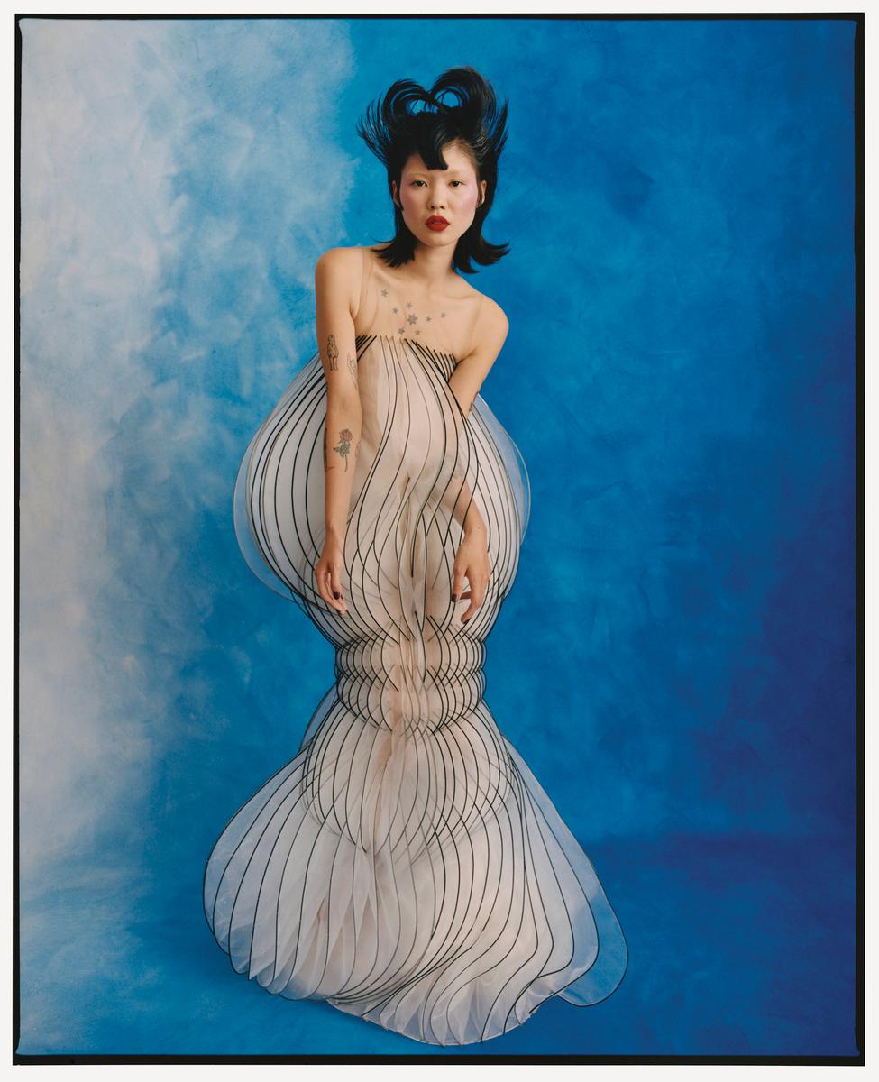 a woman in a white dress with a blue background