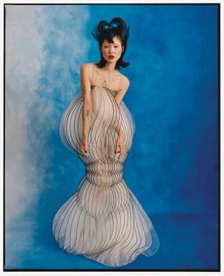 a woman in a white dress with a blue background