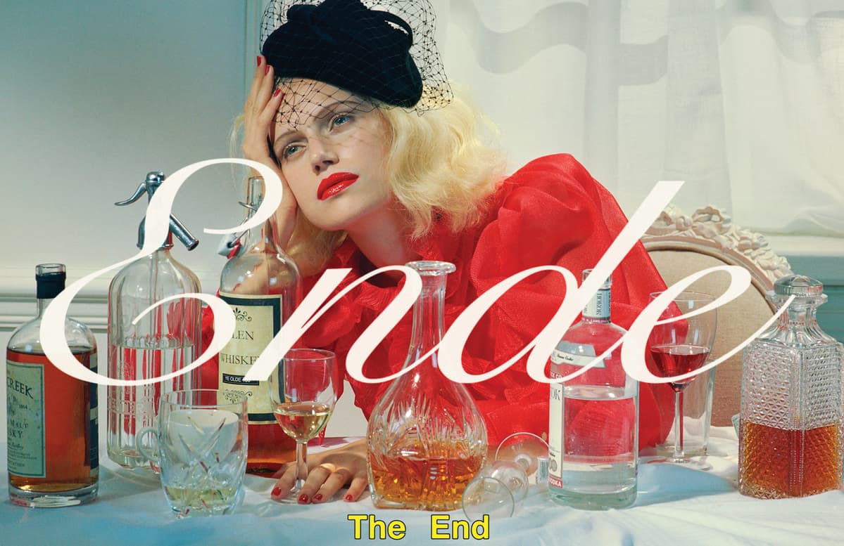 a woman sitting at a table with bottles and glasses