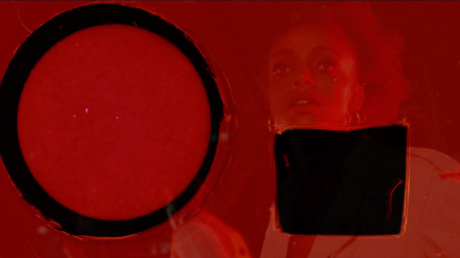 a woman looking at a cell phone with a red background