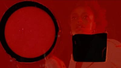 a woman looking at a cell phone with a red background