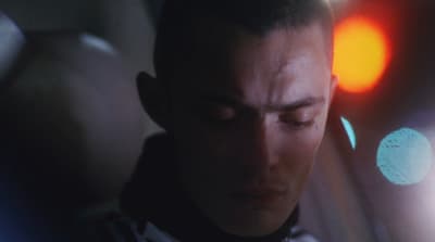 a man with his eyes closed looking at his cell phone