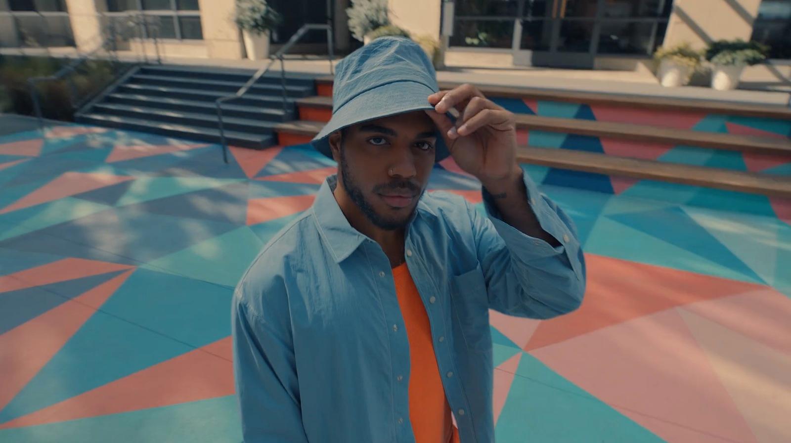 a man in a blue shirt and orange tie