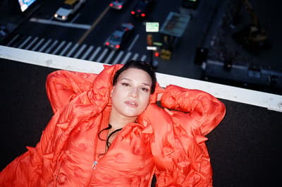 a woman in an orange dress laying on the ground