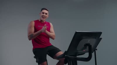 a man standing on a stationary exercise bike
